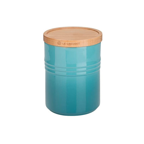 Teal storage jar with a wooden lid on a white background